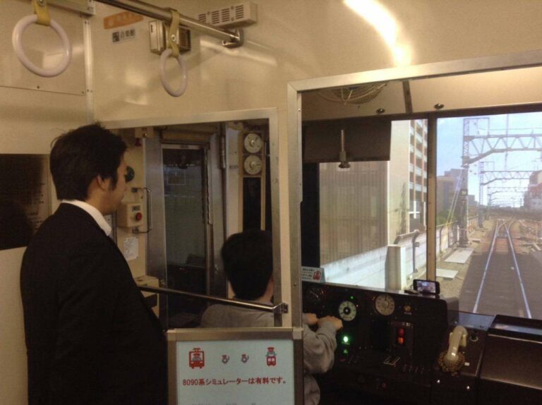 Salah satu pengunjung yang mencoba bermain di Simulator KRL seri 8090. Dipantau oleh staf produsen simulator, Ongakukan.